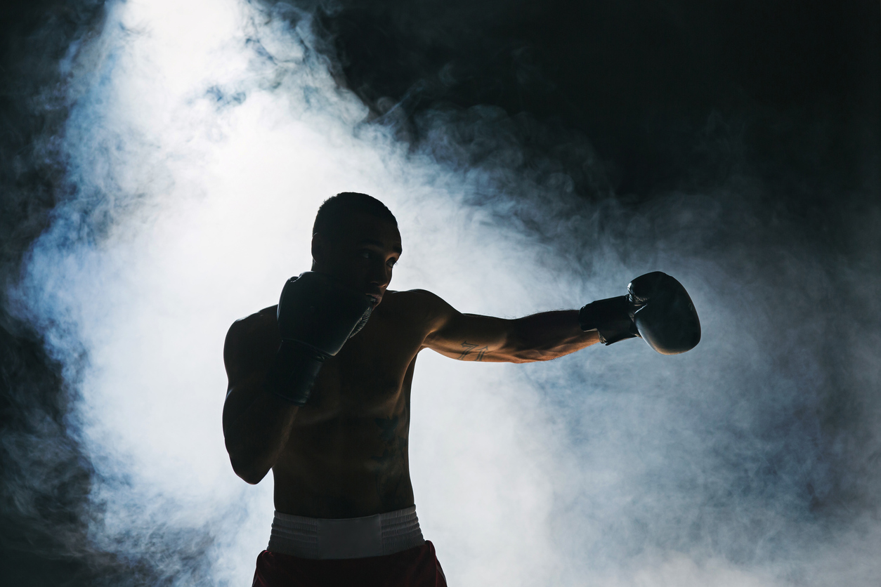 HOw to make the break out: Afro american male boxer. Young man boxing workout in a fitness club. Muscular strong man on background black studio